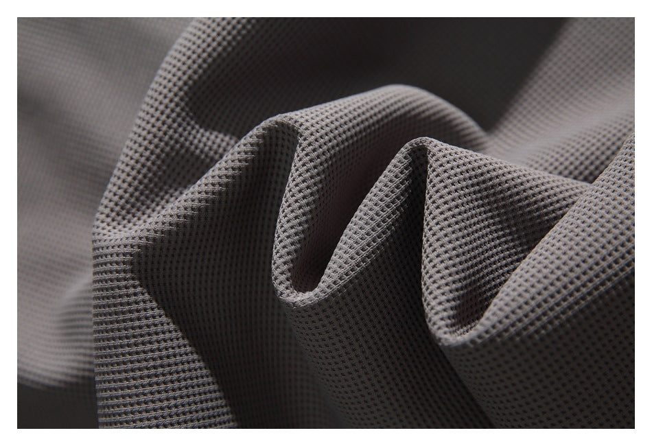 Close-up of dark gray textured fabric arranged in soft folds.