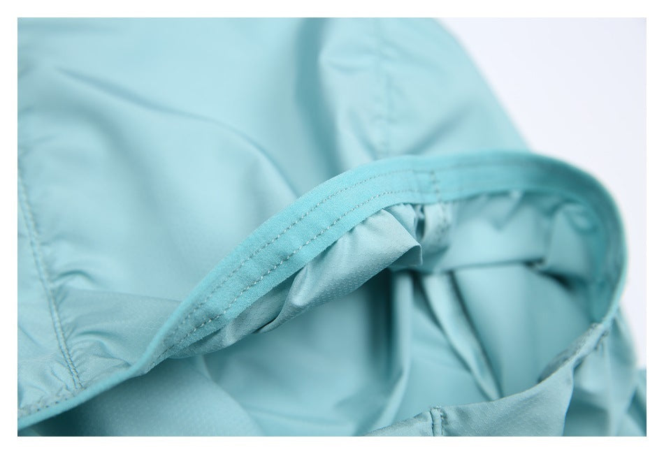Close-up of a curved, double-stitched edge on aqua garment fabric.