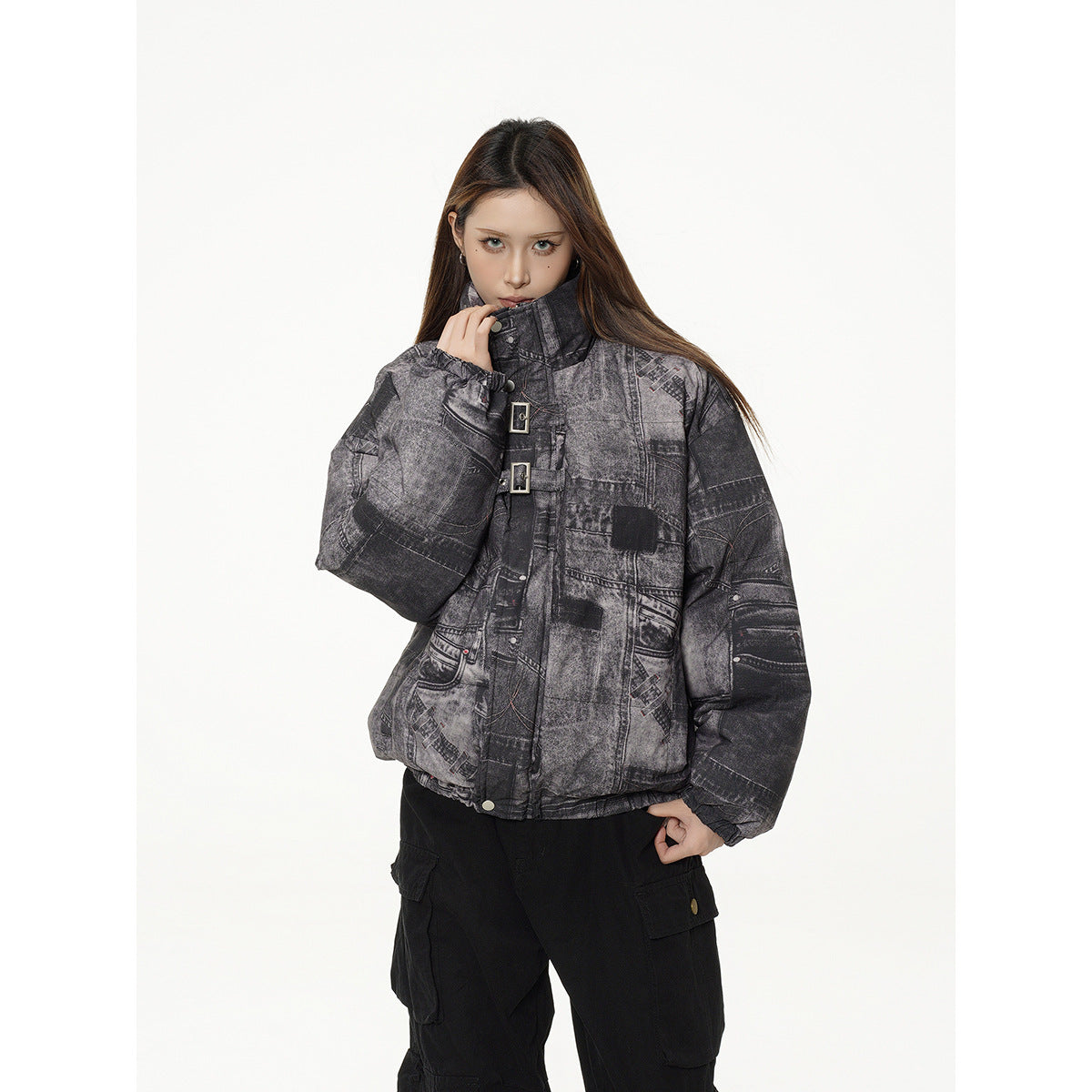 Model wearing a charcoal gray patchwork-print padded jacket with a high collar and buckle closures, shown from the front.