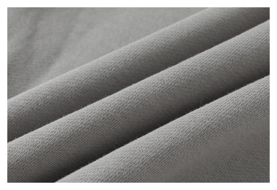 Macro view of the soft-looking knit texture on gray sweatpants.