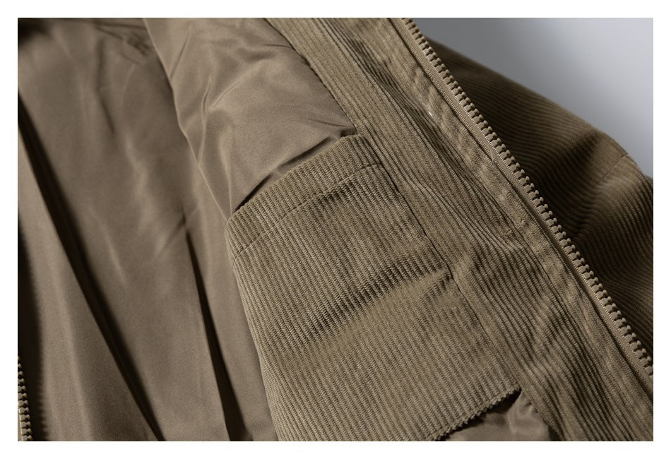 Close-up of an open brown corduroy jacket showing its smooth lining and an interior pocket.