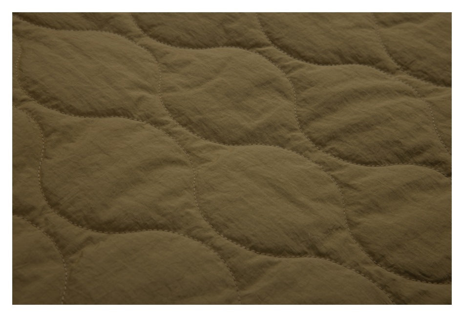 Close-up showing the olive-brown jacket's quilted stitching and fabric texture.