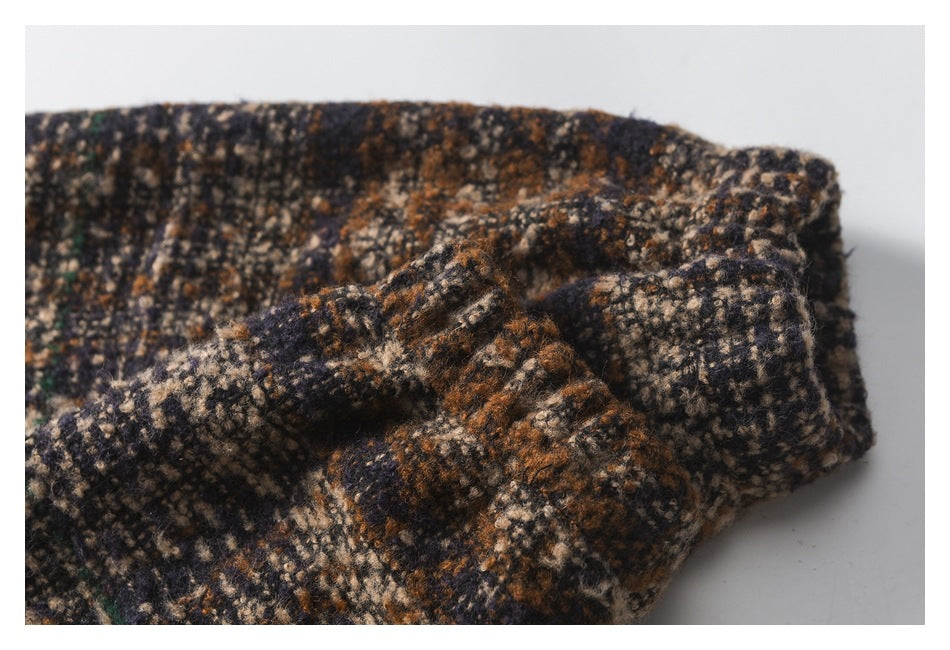 Close-up of a folded edge and seam in mottled brown, navy, beige, and green fabric.
