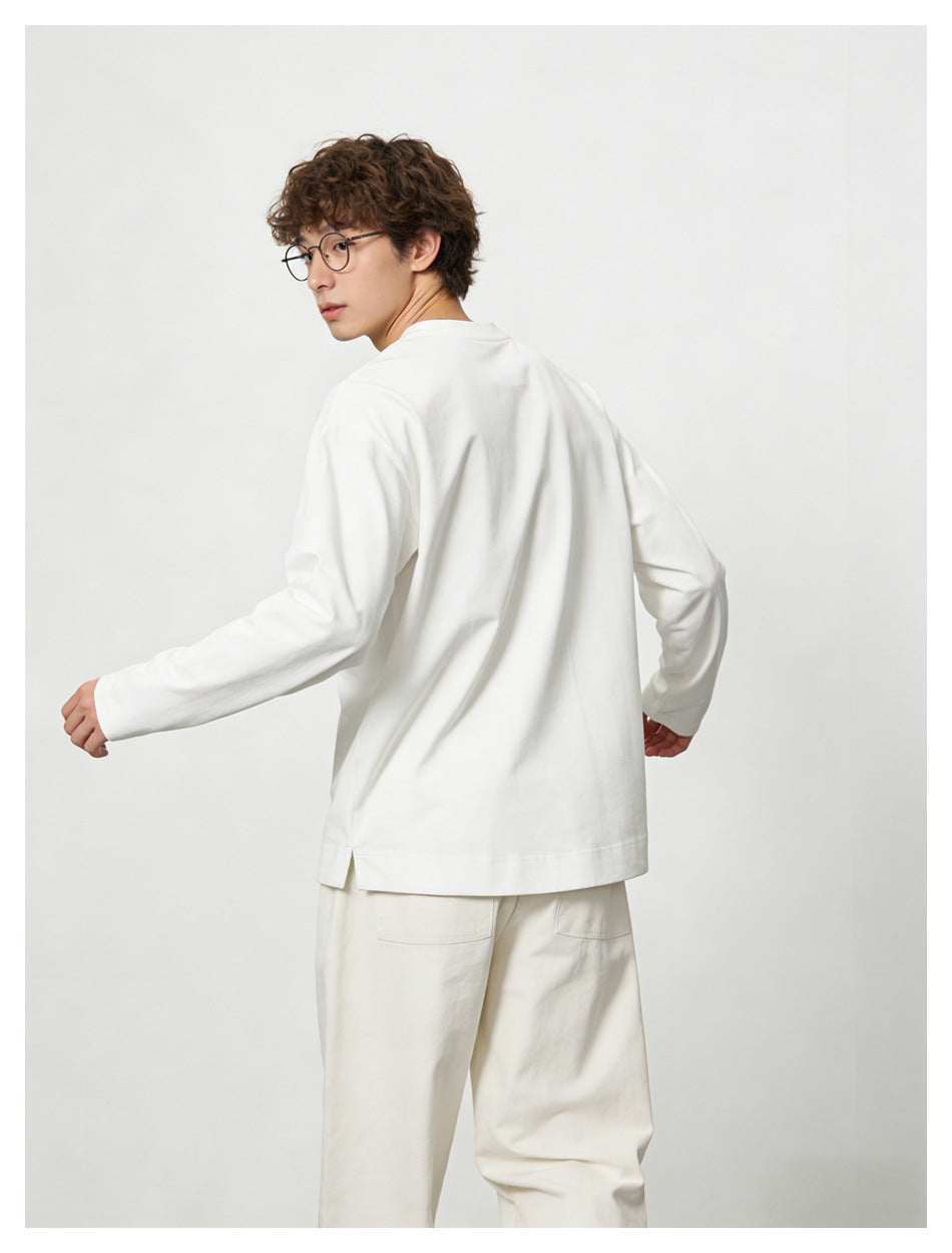 Rear view of a model wearing a white long-sleeve crewneck top with loose white trousers.