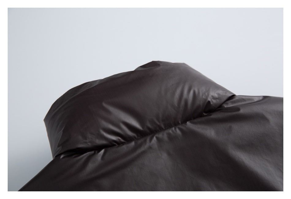 Close-up of dark charcoal outerwear fabric draped in soft folds.
