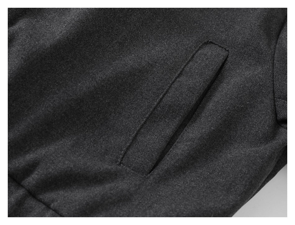Close-up of a charcoal coat with a narrow diagonal welt pocket.
