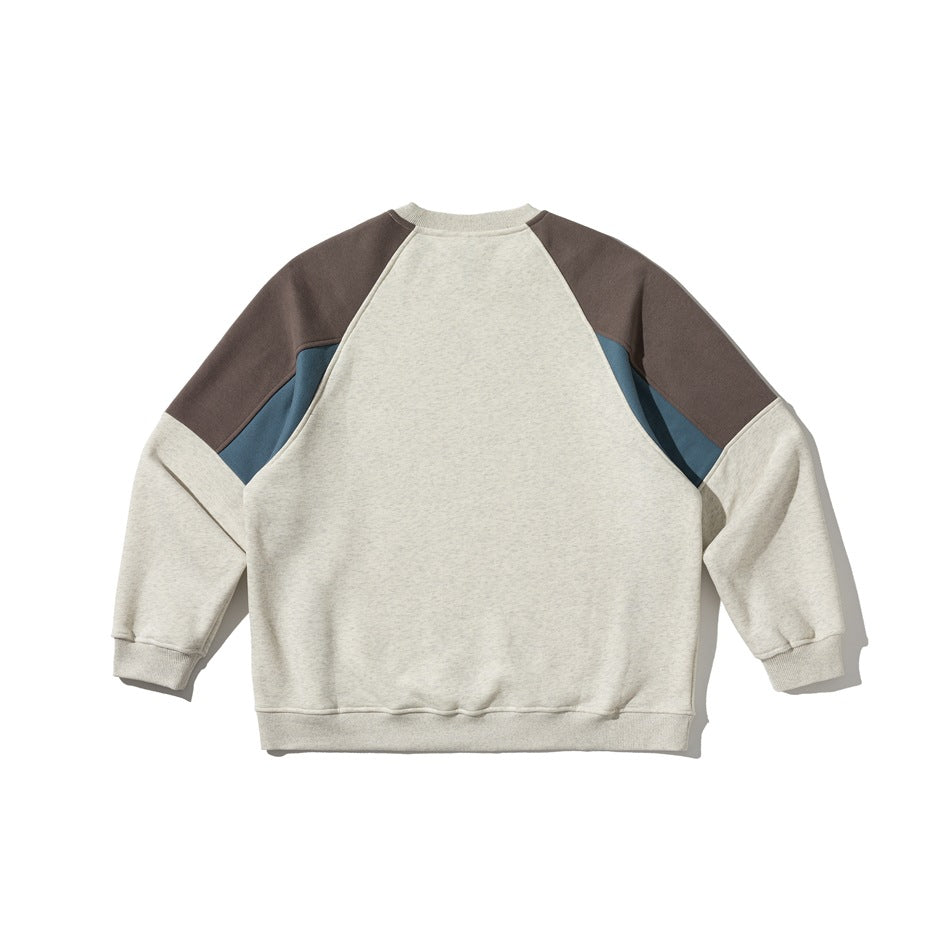 Back view of an oatmeal sweatshirt with charcoal shoulder panels and muted blue inserts.