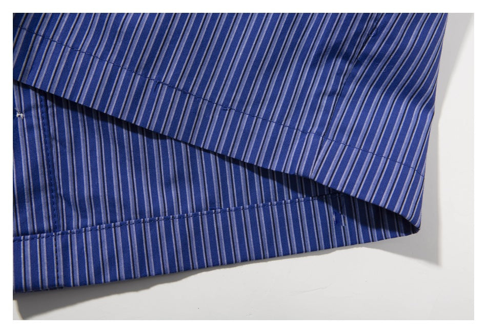 Close-up of the stitched hem on a blue shirt with narrow vertical stripes.