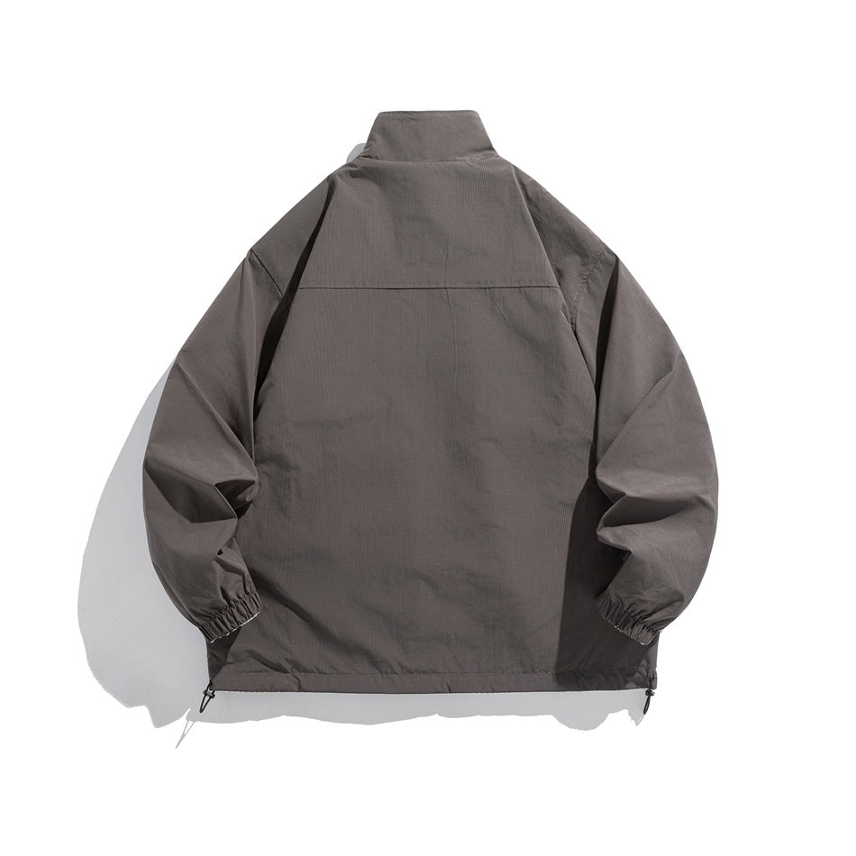 Back view of smooth gray stand-collar jacket with back yoke seam, elastic cuffs and drawcord hem, flat lay