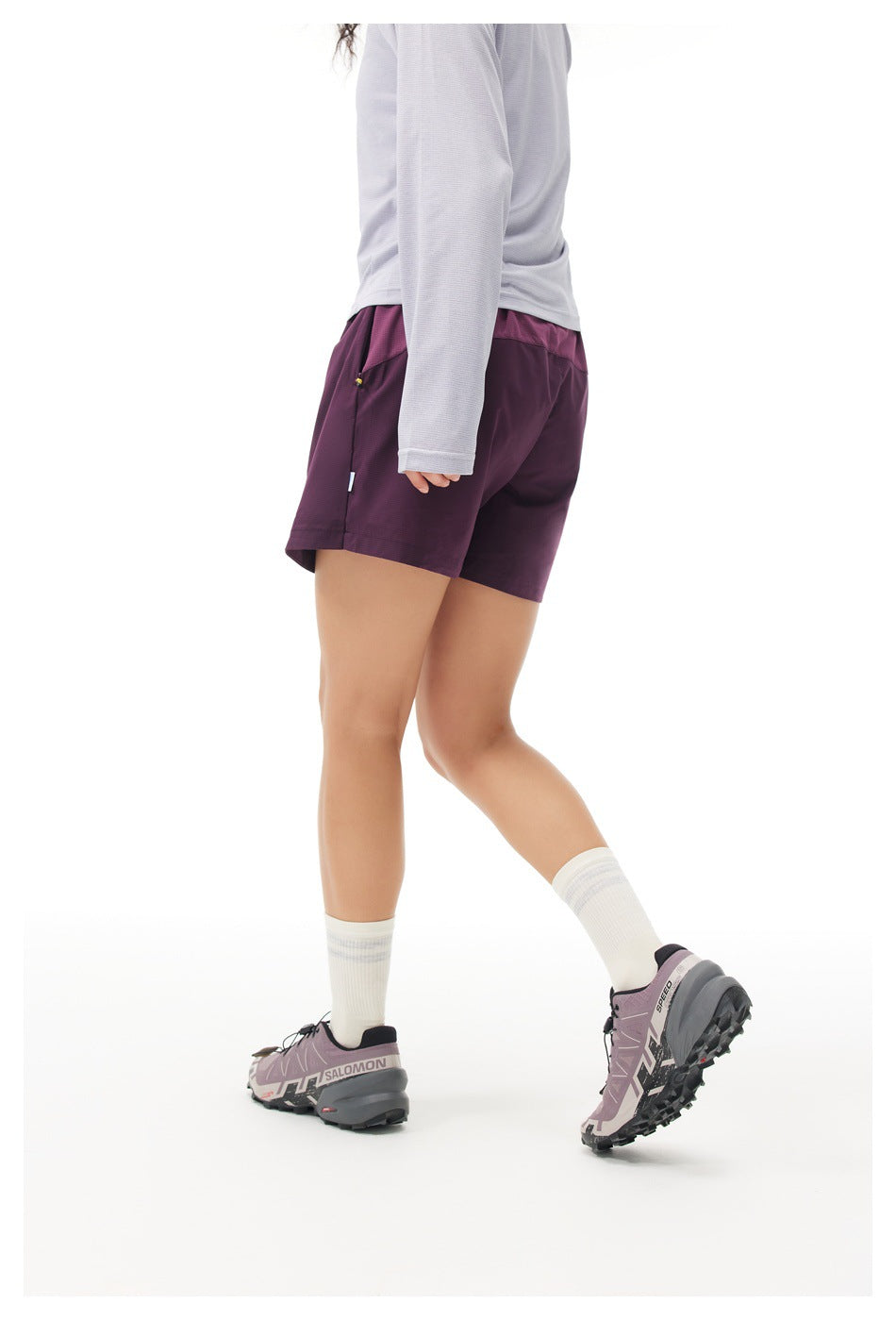 Model wearing plum athletic shorts, shown from a rear three-quarter angle.
