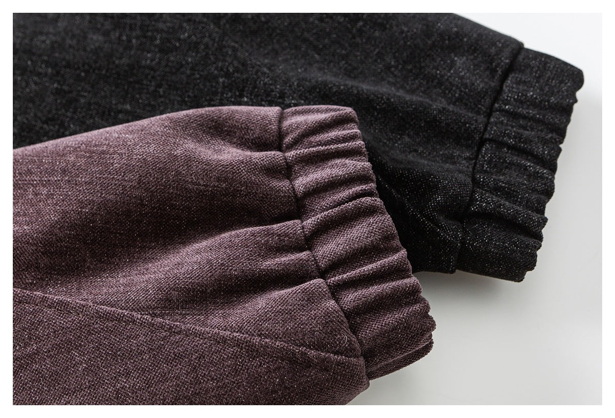 Close-up of gathered sleeve cuffs in plum and black textured fabric.