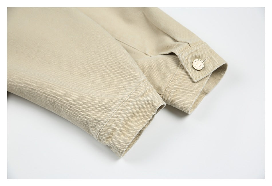 Close-up of beige jacket sleeves showing stitched cuffs and a buttoned cuff tab.