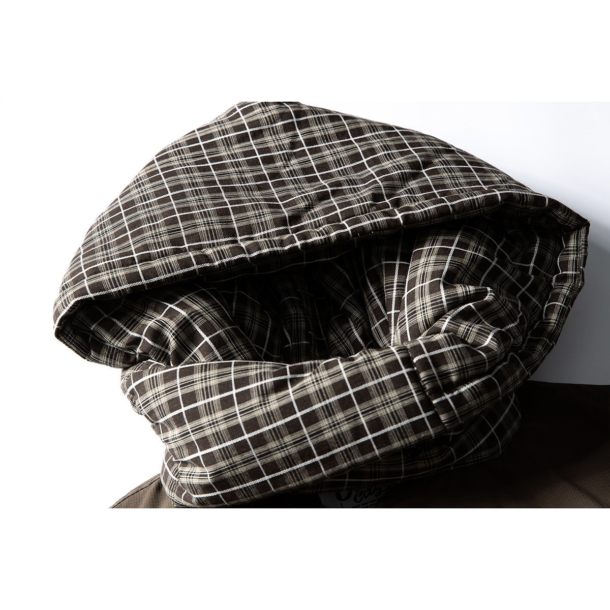 Close-up of a dark brown jacket's black-and-white plaid hood.