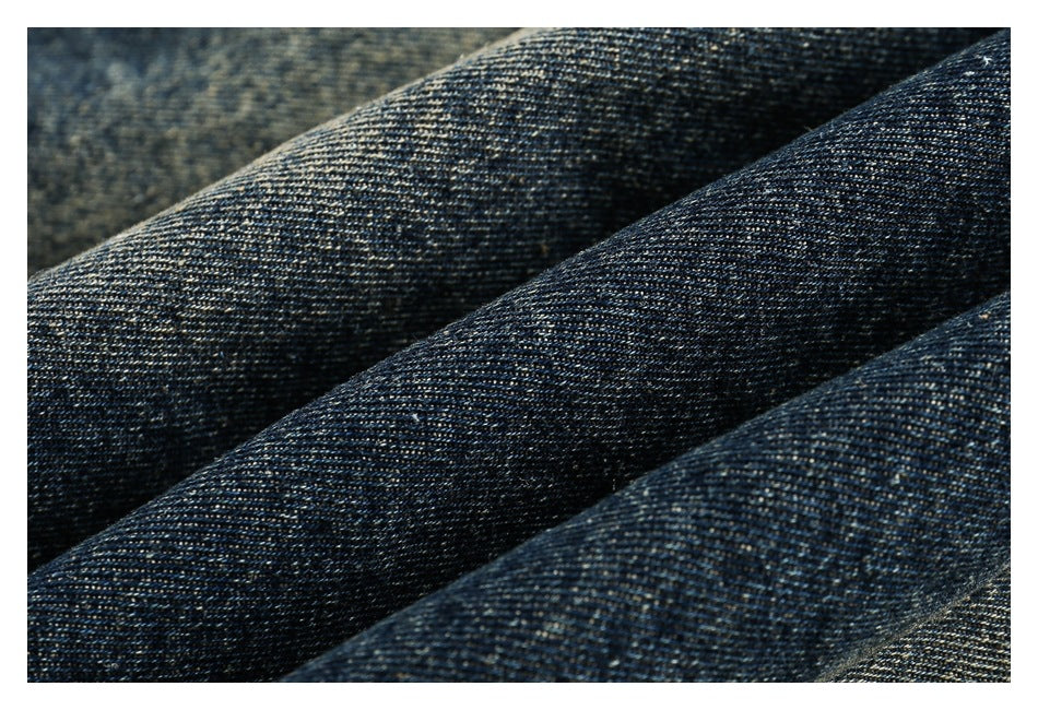 Extreme close-up of dark blue denim fabric with visible diagonal weave.