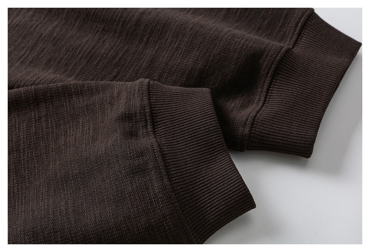 Close-up of dark brown sweatshirt sleeves and their ribbed cuffs.