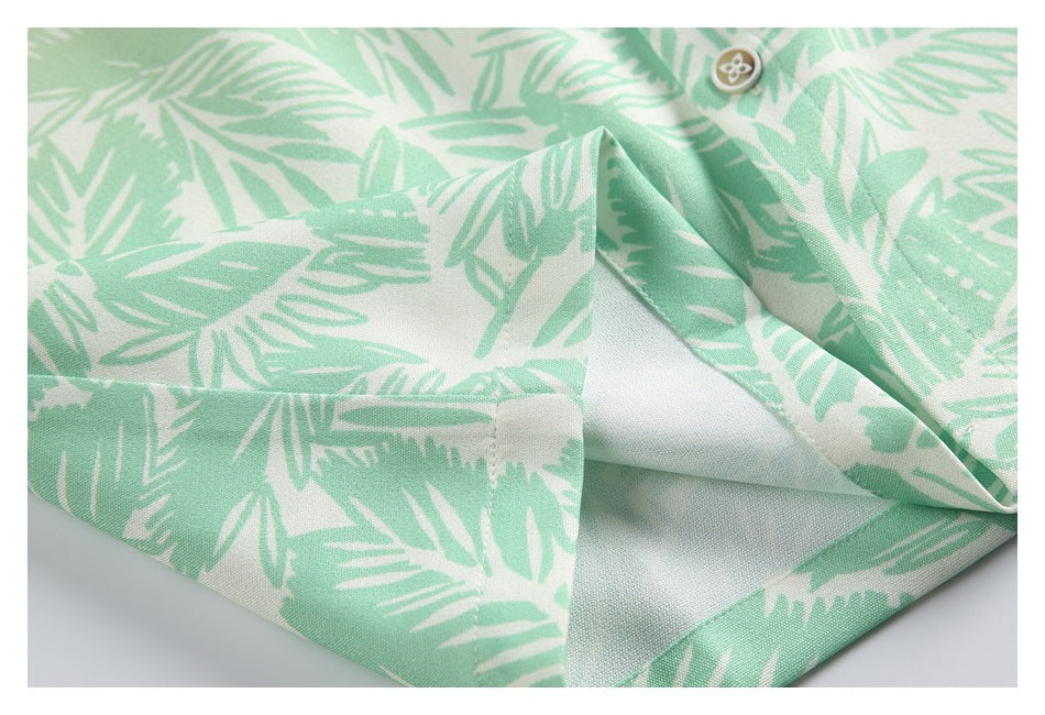 Close-up of the hem and stitching on a mint green and cream leaf-print shirt.