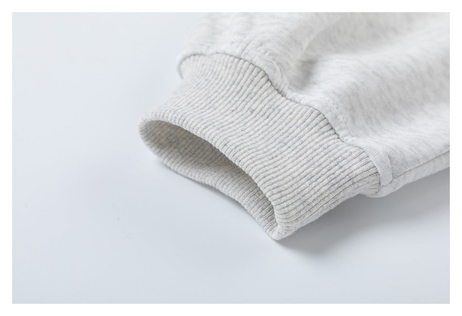 Close-up of a ribbed cuff on a light heather-gray hoodie sleeve.