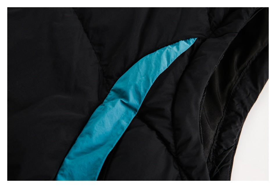 Close-up of black padded garment with a curved turquoise accent panel and stitched seams.