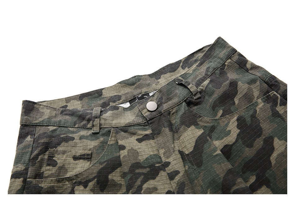 Upper front of olive, brown and black camouflage trousers, showing the waistband, button, belt loops and pockets.