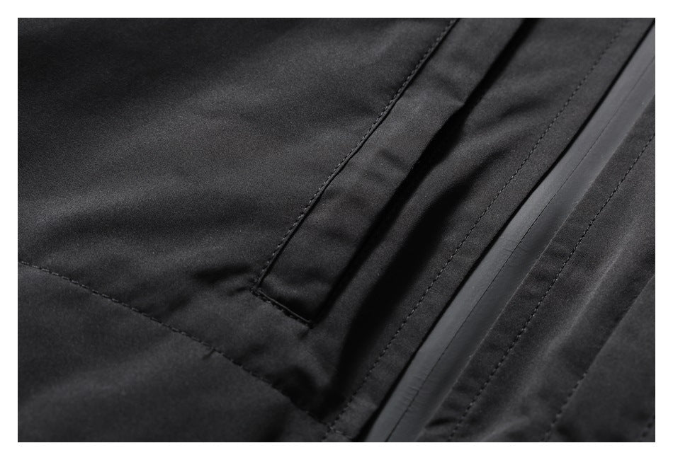Close-up of black jacket fabric showing a pocket seam and a covered zipper.