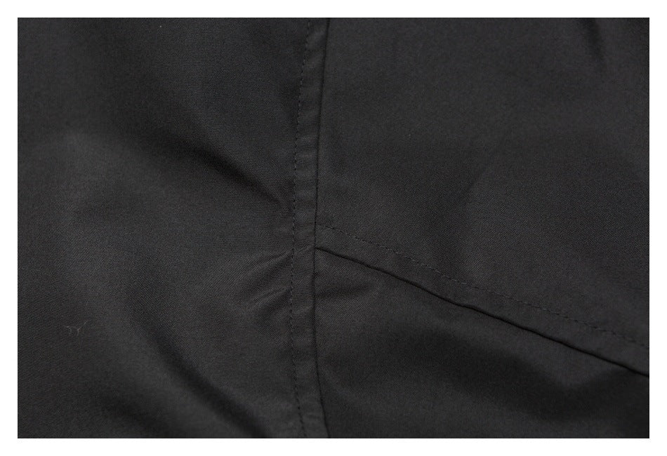 Close-up of black garment fabric showing intersecting stitched seams.