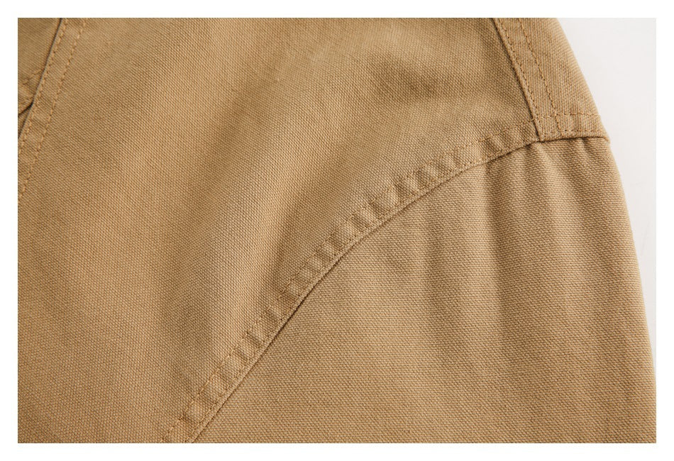 Close-up showing the tan jacket's curved stitched seam and fabric texture.
