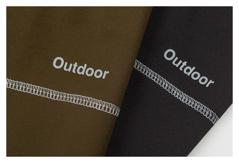 Close-up of olive and black fabric panels with white overlock stitching and white “Outdoor” lettering.
