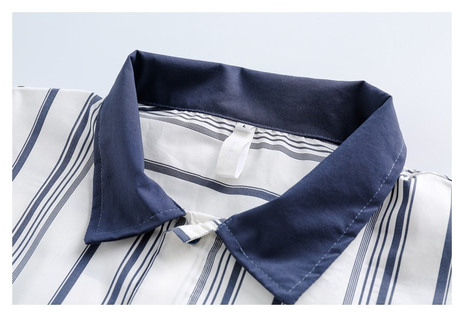 Close-up of a white shirt with navy stripes and a solid navy pointed collar.