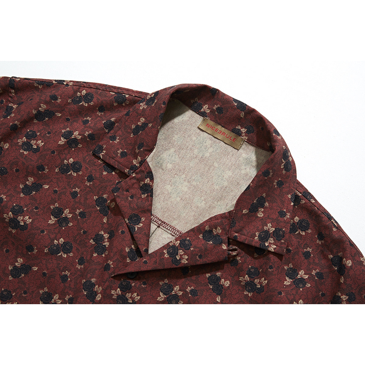 Close-up of a burgundy floral shirt collar and inner neck label.