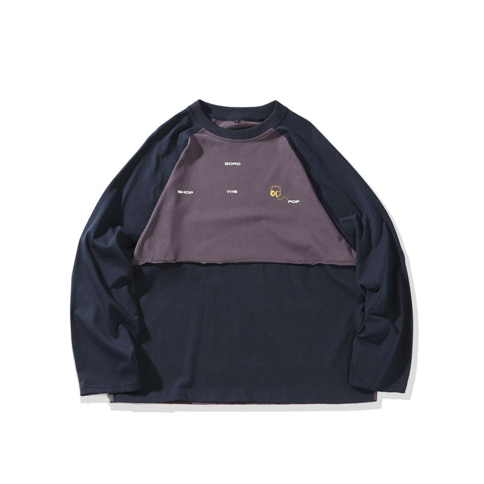 Navy long-sleeve shirt laid flat, with a muted purple chest panel and small graphic text.