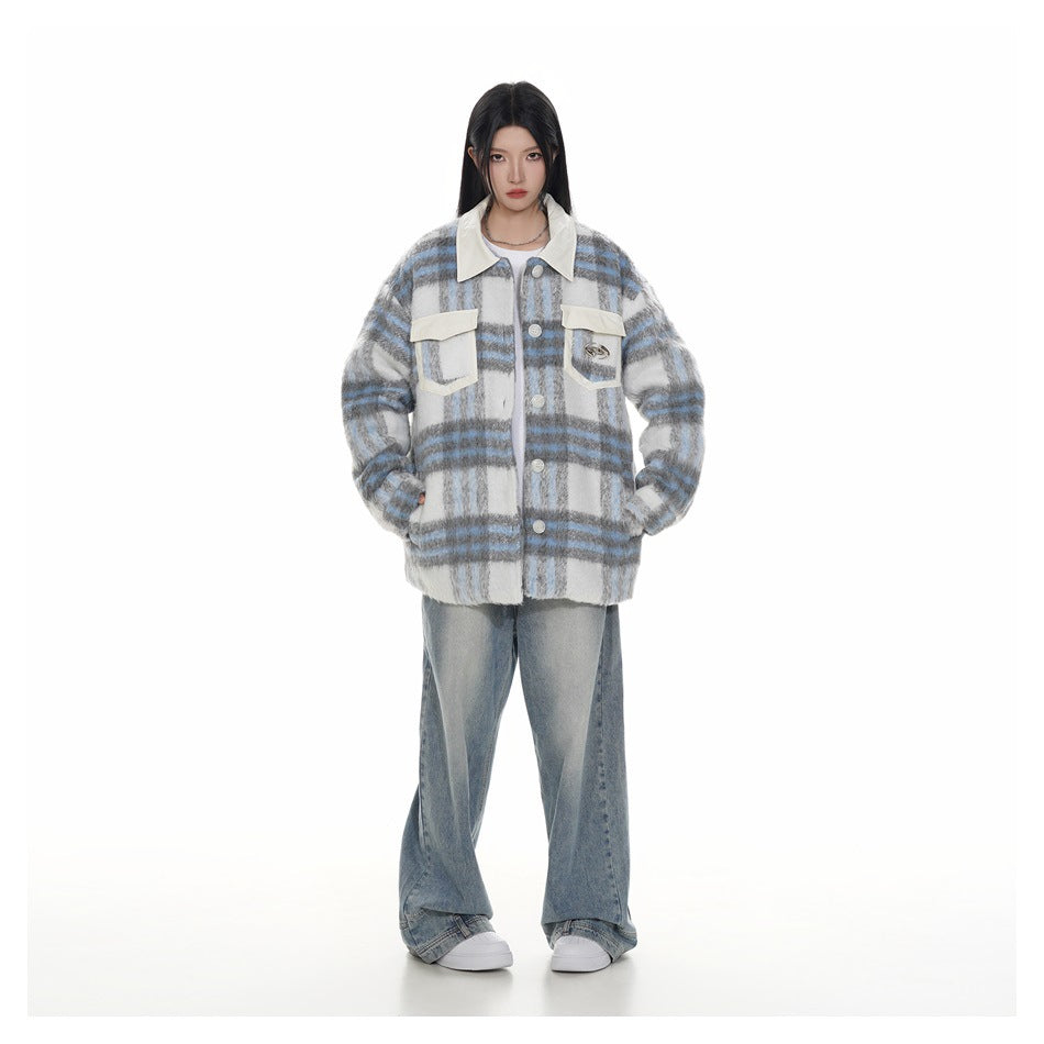 Full-length front view of a model wearing a gray, white and blue plaid jacket, wide-leg jeans and white sneakers.
