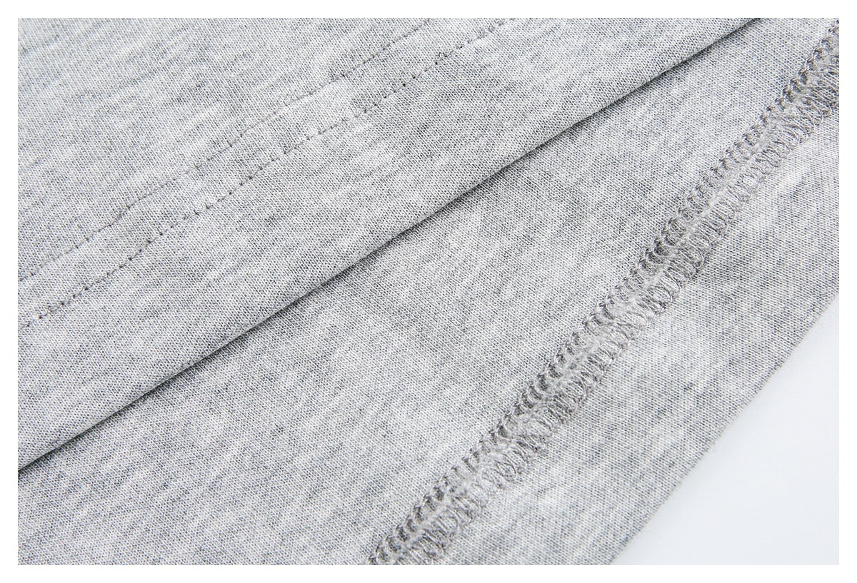 Close-up of heather gray fabric showing stitched seams and an overlocked edge.