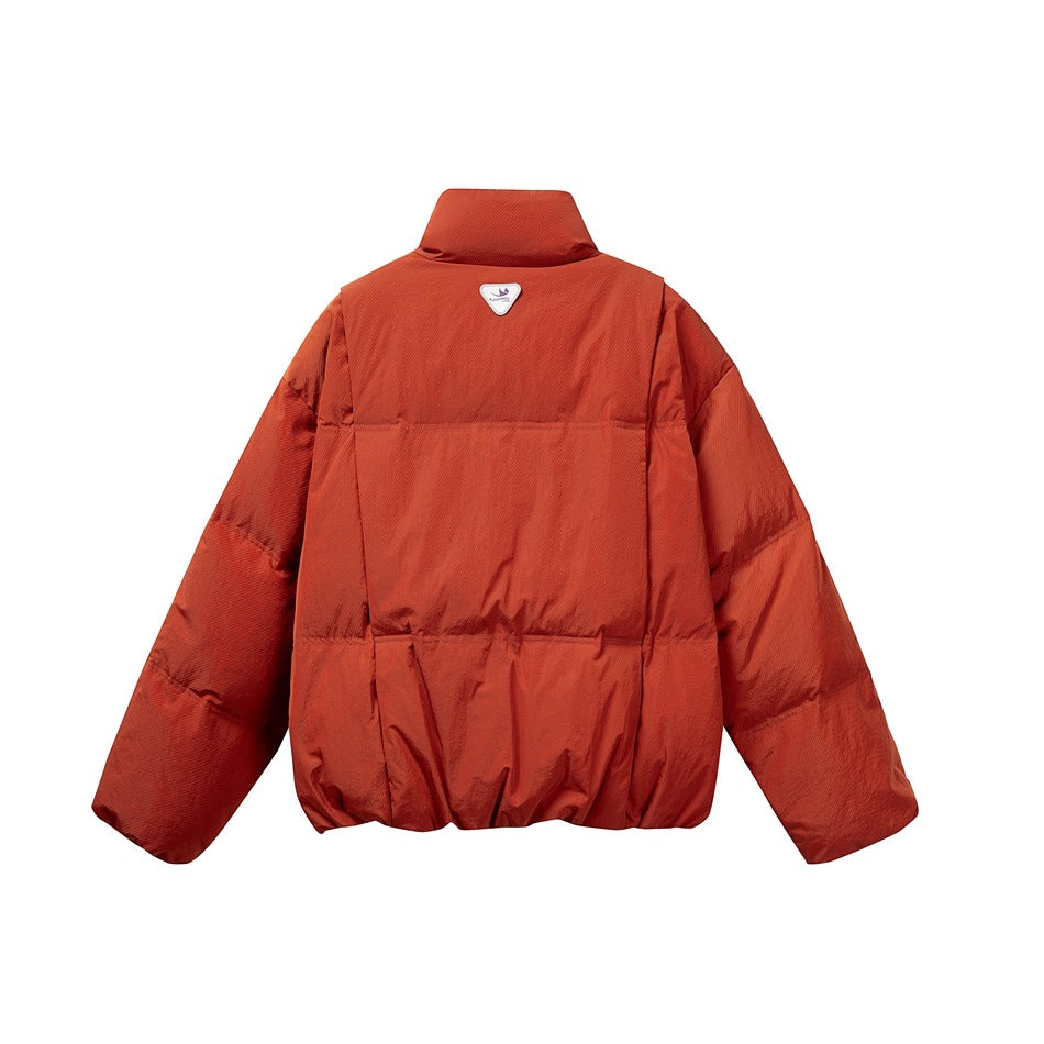 Back view of a rust-orange quilted puffer jacket with a high collar and a small triangular patch at the upper back.