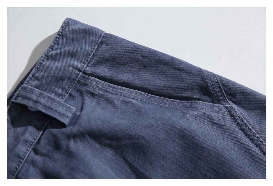 Close-up of a navy garment waistband, belt loop and stitched pocket edge.