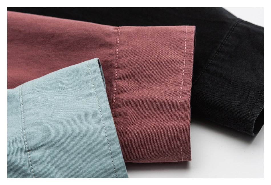 Close-up of shirt cuffs in dusty rose, pale blue, and black colorways.