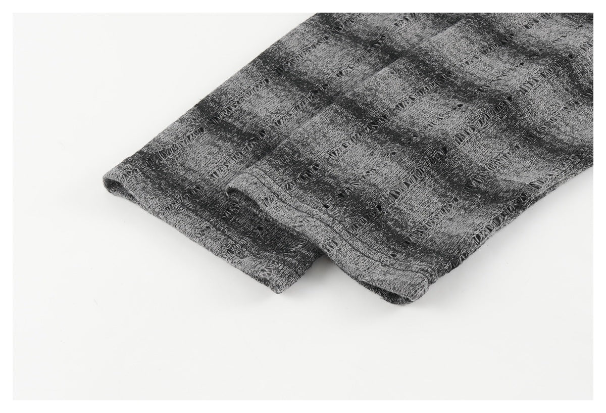 Close-up of the gray-and-black patterned top's folded hem and stitching.