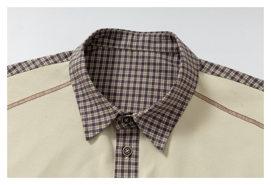 Close-up of a pointed brown plaid collar and button placket against a cream top with visible seam stitching.