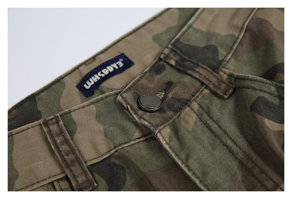 Close-up of the waistband, button and sewn-in label on olive, brown and black camouflage trousers.