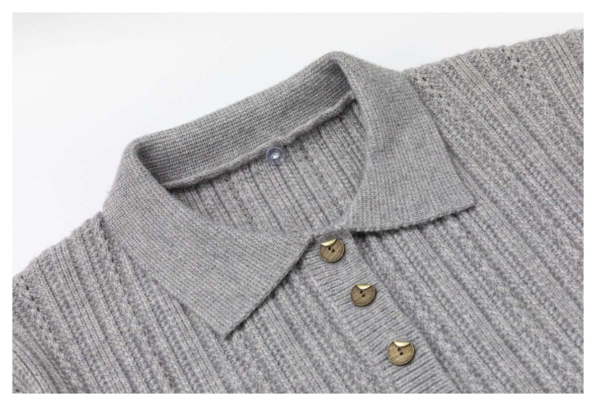 Close-up of a gray rib-knit sweater's pointed collar, neckline, and three brown buttons.