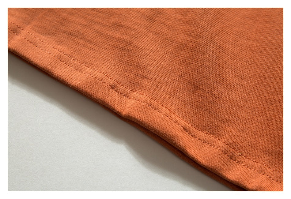 Close-up of the double-stitched hem on orange fabric.