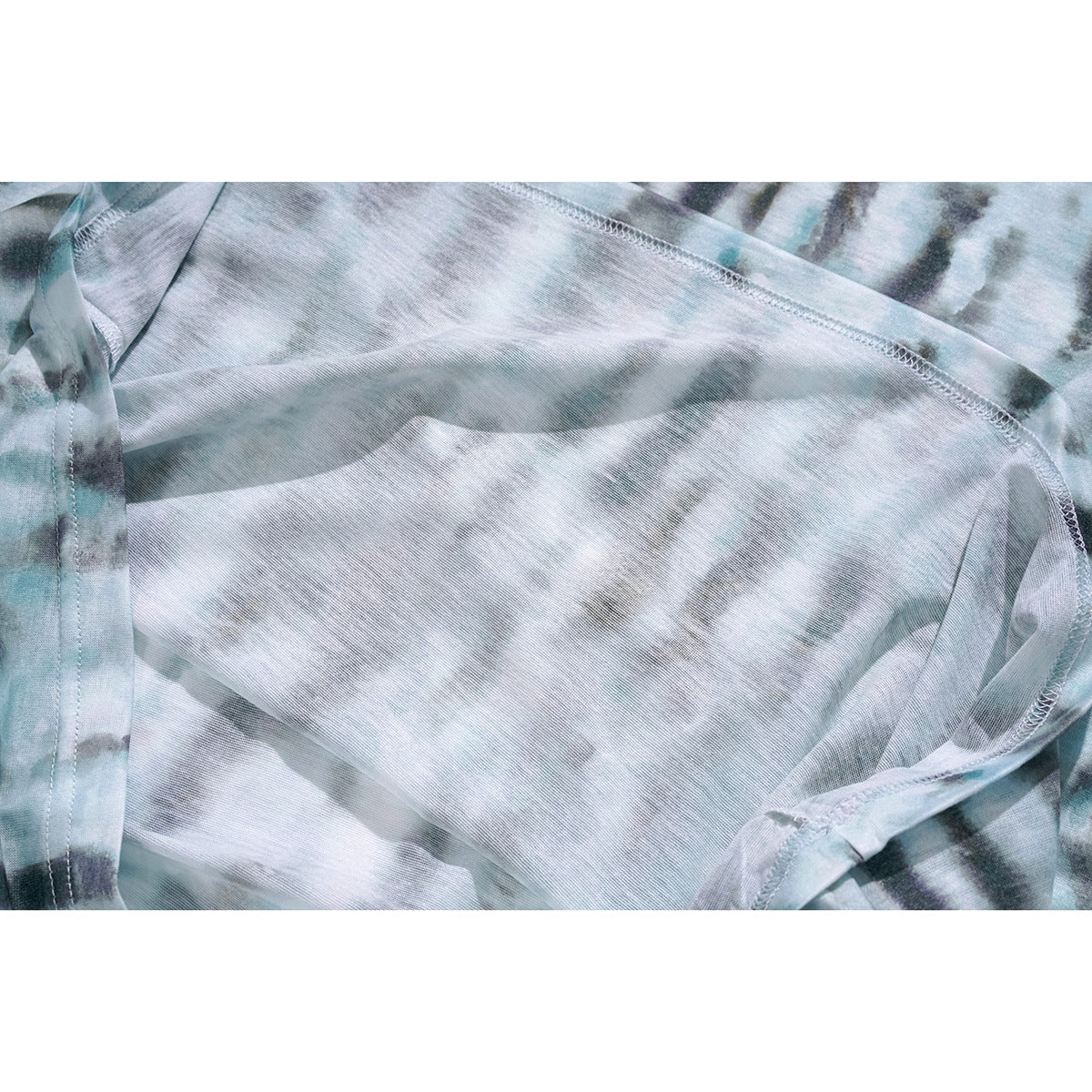 Inside view of the pale blue-gray tie-dye top, showing fabric and overlocked seams.