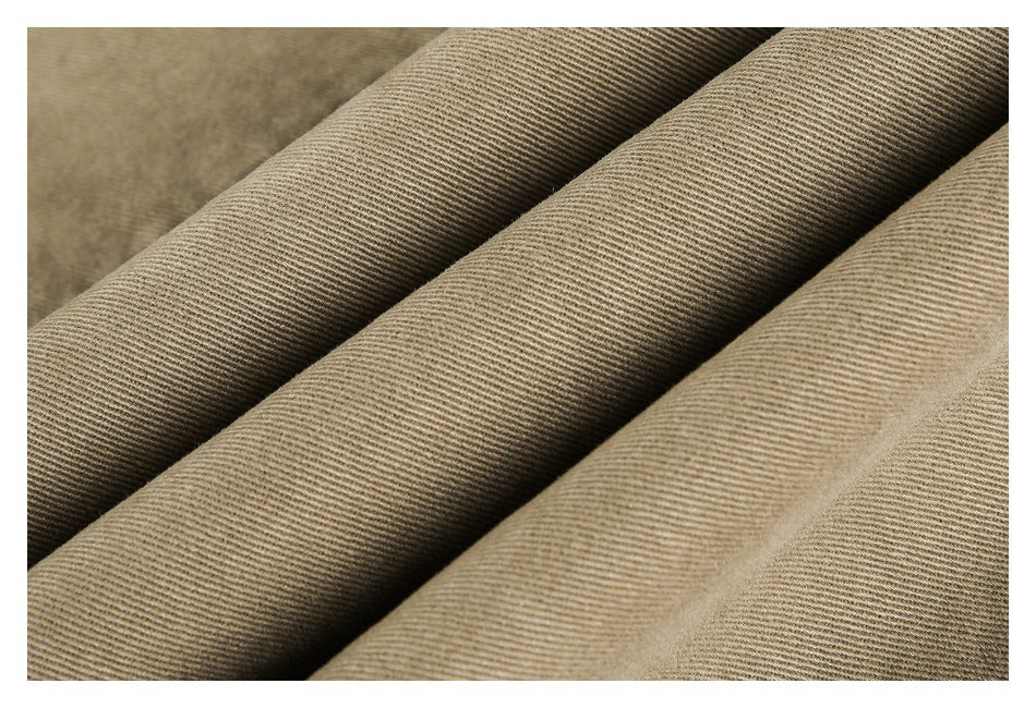 Close-up of tan twill fabric arranged in soft folds, showing its fine diagonal weave.