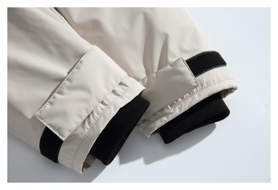 Close-up of light beige jacket cuffs with black ribbed inner cuffs and hook-and-loop tabs.