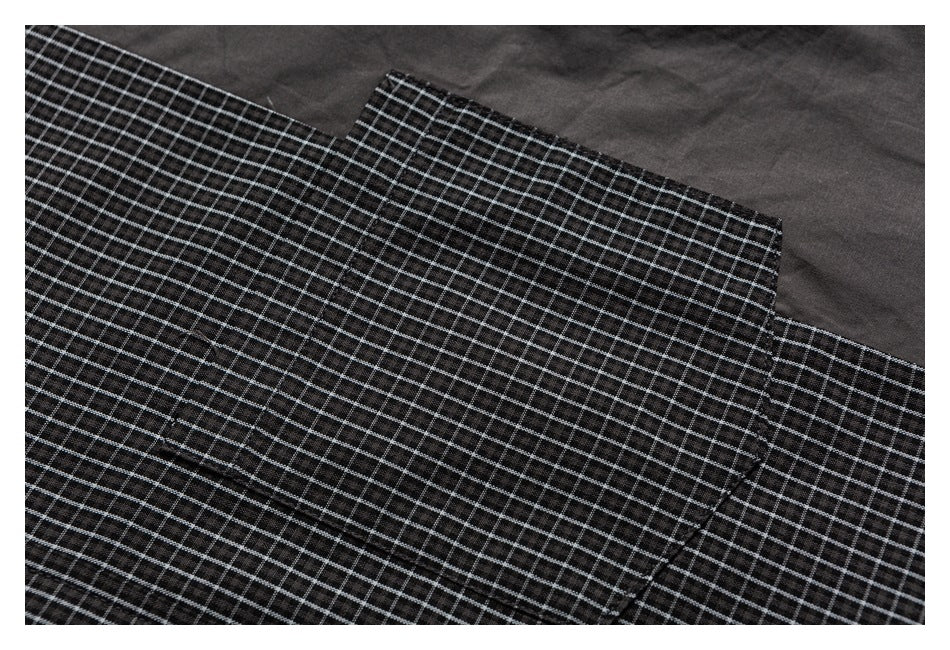 Close-up of overlapping black-and-white checked shirt panels and seams.