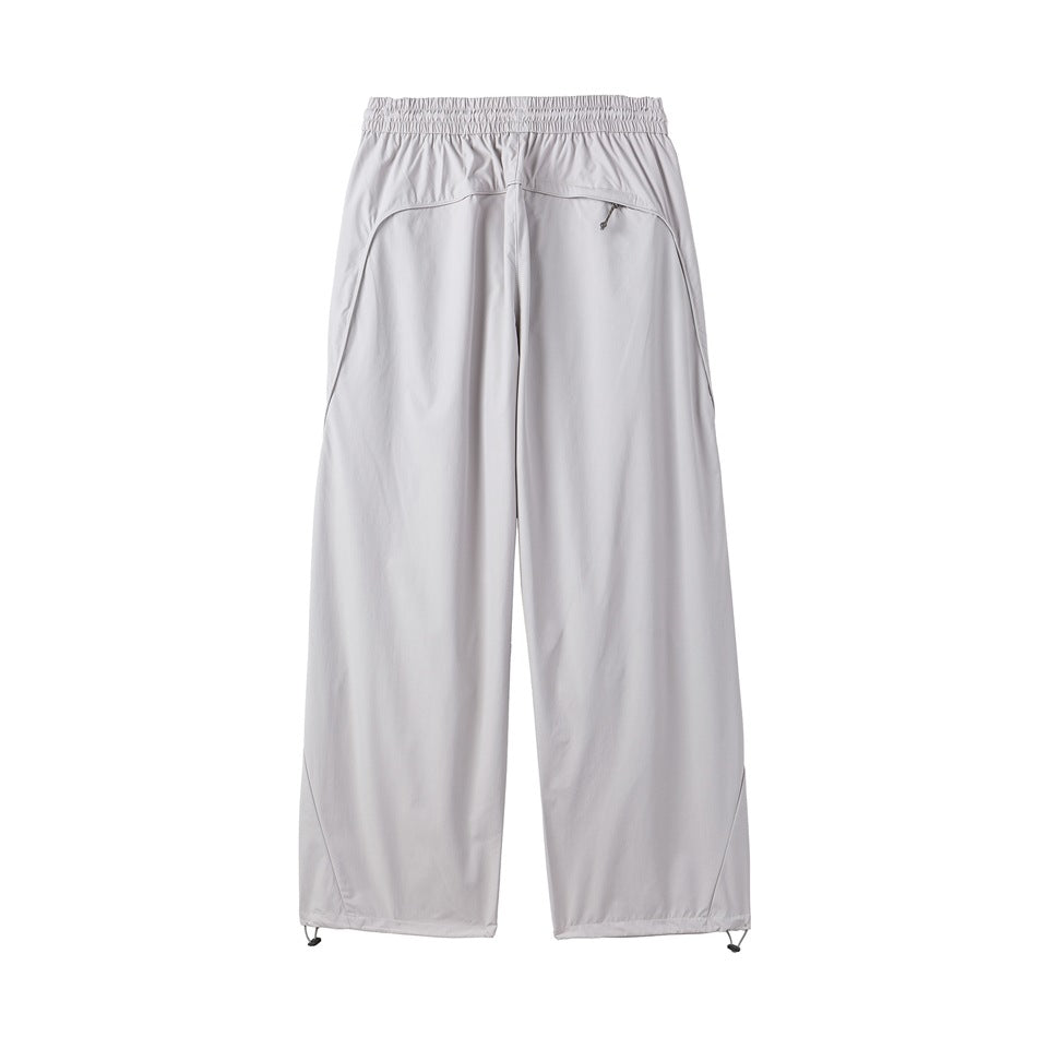 Rear view of light gray wide-leg pants with an elastic waistband, zip pockets, and adjustable ankle cords.