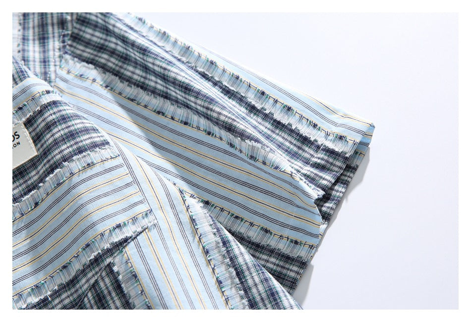 Close-up of the short sleeve and cuff, showing blue-gray plaid, fine stripes, and fringed seam details.