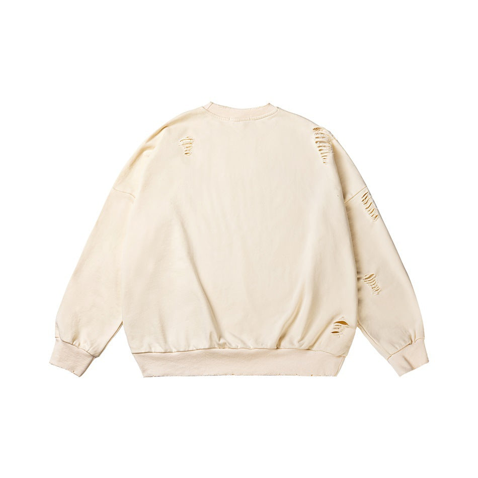 Ivory crewneck sweatshirt with long sleeves, ribbed cuffs and hem, and distressed slashes across the front and sleeves.
