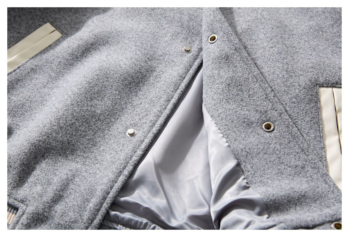 Open gray jacket showing its light lining, snap fasteners, and cream-colored pocket trim.