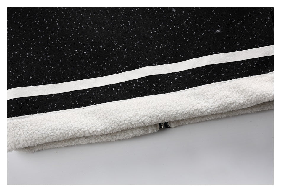 Close-up of the jacket hem with black speckled fabric, a white stripe and thick white fleece trim.