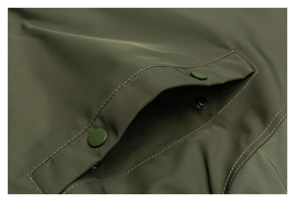Close-up of a flap pocket on the olive parka, secured with snap buttons.